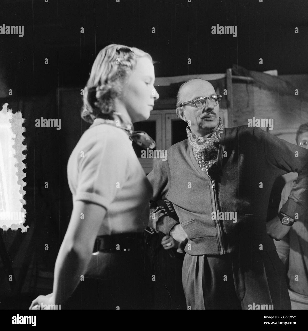 Film. Trial recordings Stars shine everywhere Annotation: Kitty Jansen and right the director Gerard Rutten. Location: Cinetone Studio Duivendrecht Date: 13 October 1952 Location: Duivendrecht Keywords: actors, film, directors, work recordings Personal name: Janssen, Kitty, Rutten, Gerard Stock Photo