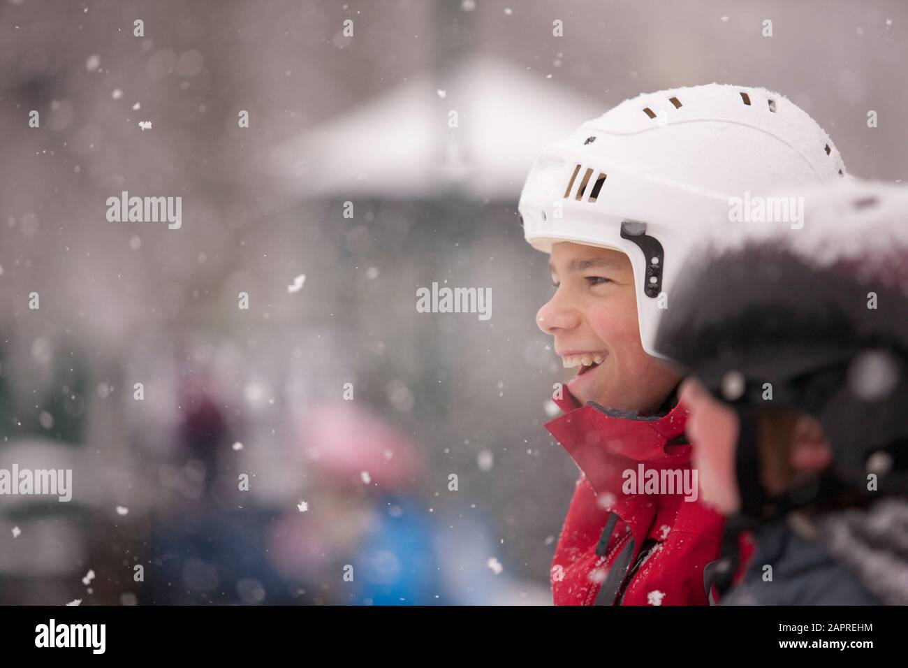 Two children wearing helmets standing in a snowfall Stock Photo