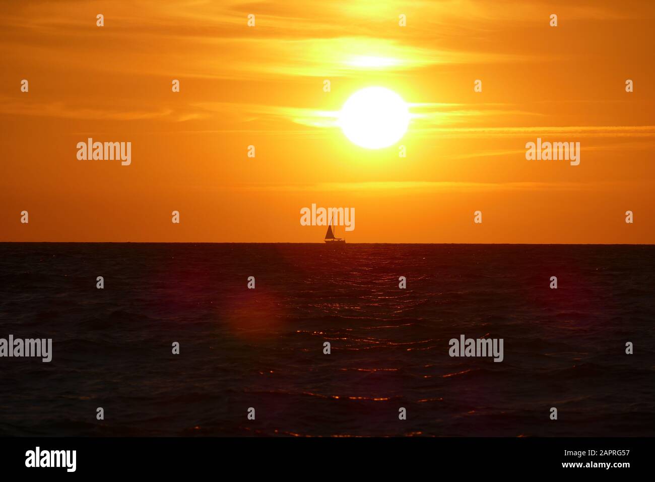 Sailing ship in the sea on the horizon at sunset Stock Photo - Alamy