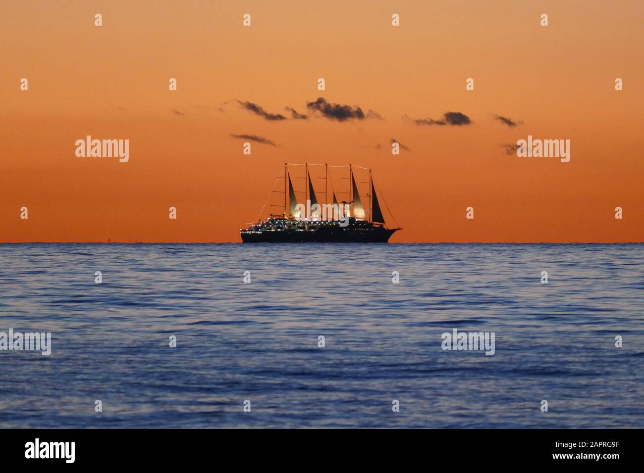 Sailing ship on the horizon at sunset Stock Photo - Alamy