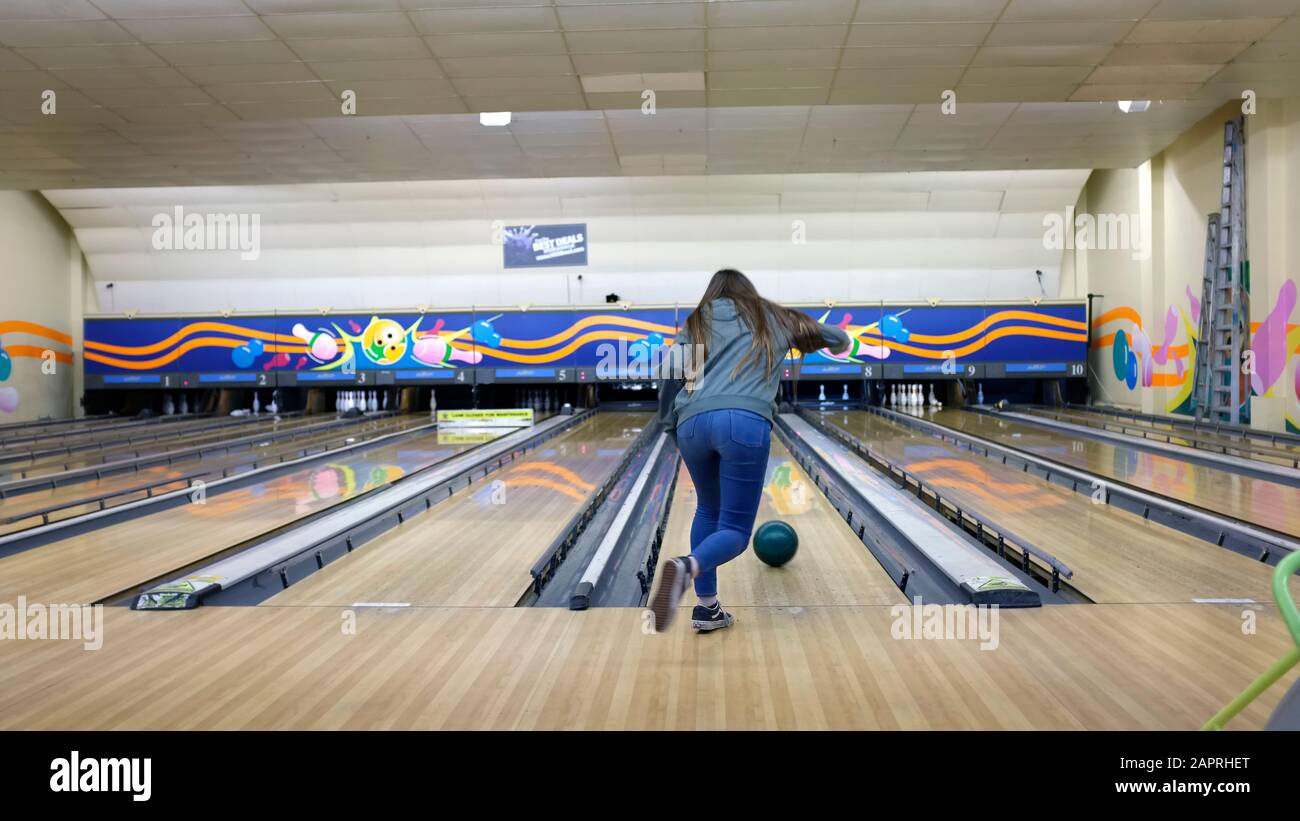 Teenage girl bowling at a ten pin bowling alley. Stock Photo