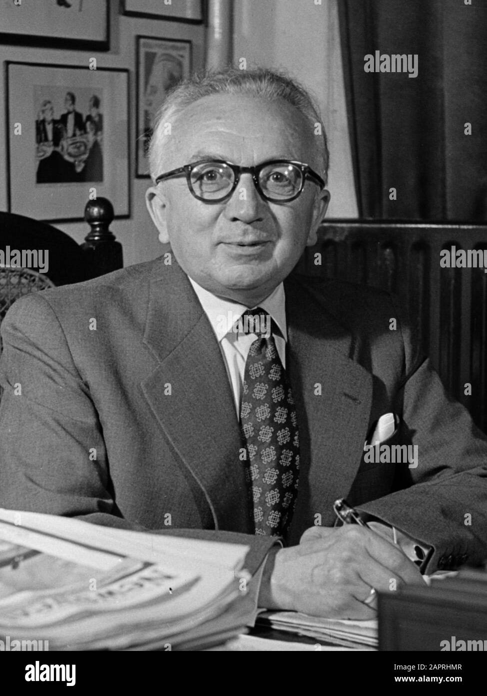 De heer Dellaert aan zijn bureau thuis. Met op de achtergrond foto's en karikaturen. De heer Dellaert (1893-1960) was directeur van de KLM van 1950 tot 1960  mei 1954 Stock Photo