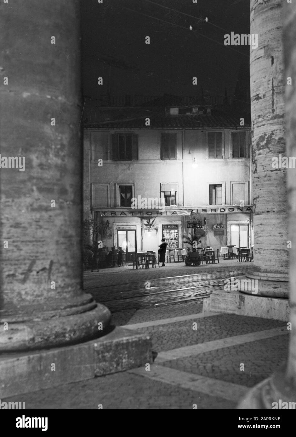 Rome: Visit to the Vatican City  A small restaurant opposite St. Peter's from the Doric Pillars Date: December 1937 Location: Italy, Rome, St. Peter's Square, Vatican City Keywords: evening, pillars, squares, restaurants, street images Institution name: Saint Pieter Stock Photo