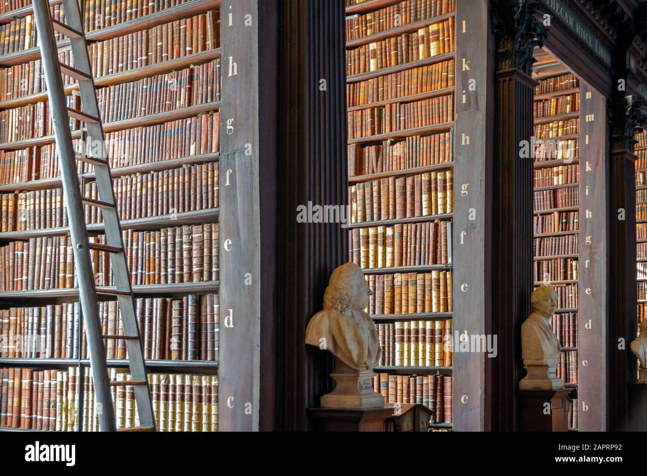 DUBLIN, IRELAND - FEB 15, 2014: Vintage library with shelves of old books in the Long Room in the Trinity College. Stock Photo