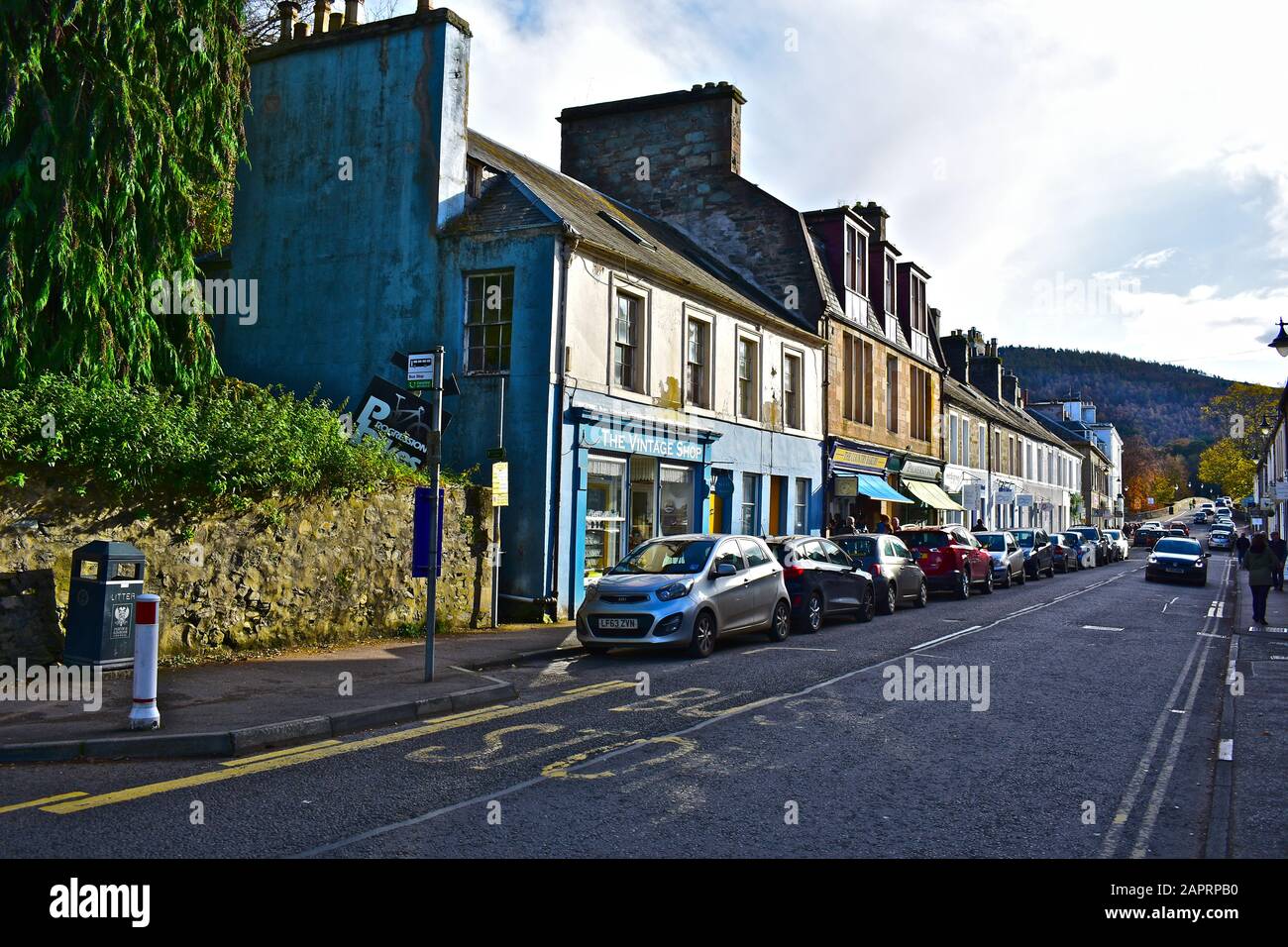 A view of the old houses and shops that line Atholl Street, the main road in the centre of Dunkeld, towards the historic bridge over the river Tay. Stock Photo