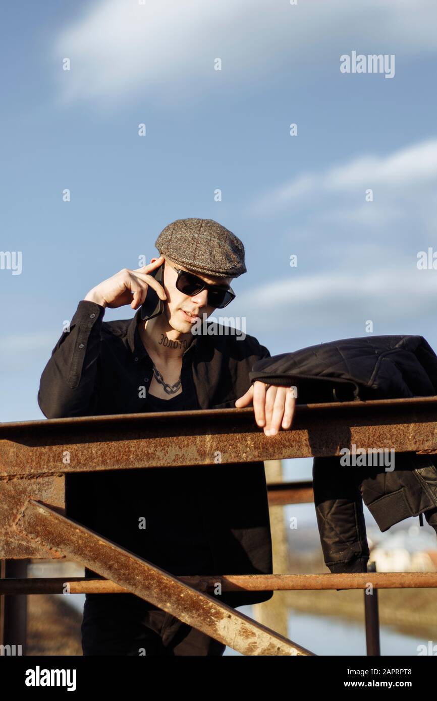 Young man speaking on smartphone, wearing sunglasses. Stock Photo
