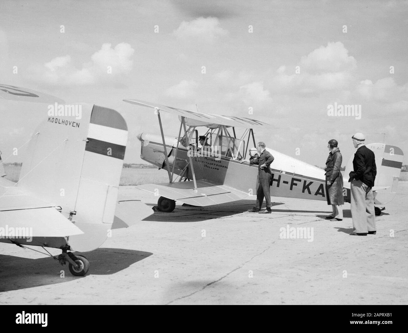 National Aviation School Holland  A Koolhoven FK-46 class plane nicknamed 'Cow of Koebeest' because of his docile flying behaviour of the National Aviation School Holland in Amsterdam Schiphol with instructor and adspirant pilot, standing a mechanic and two student-pilots Annotation: The National Aviation School Holland was located in Rotterdam Waalhaven and Amsterdam Schiphol Date: 1933 Location: Amsterdam, Rotterdam Keywords: students, teachers, mechanics, pilots, flight training, aircraft Personal name: Frits Koolhoven Stock Photo