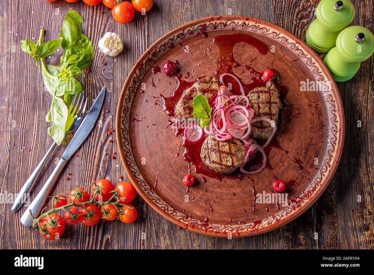 Veal medallions with cherry sauce, served with pickled onions and radishes, a gourmet dish, Close up, Horizontal orientation Stock Photo