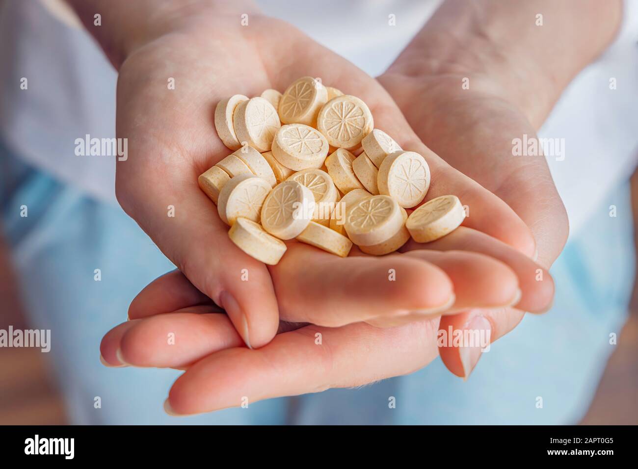 A woman holds vitamins pills in her hands. Vitamin C provides an essential nutrient for healthy bones, cartilage, teeth, and gums. An antioxidant for Stock Photo