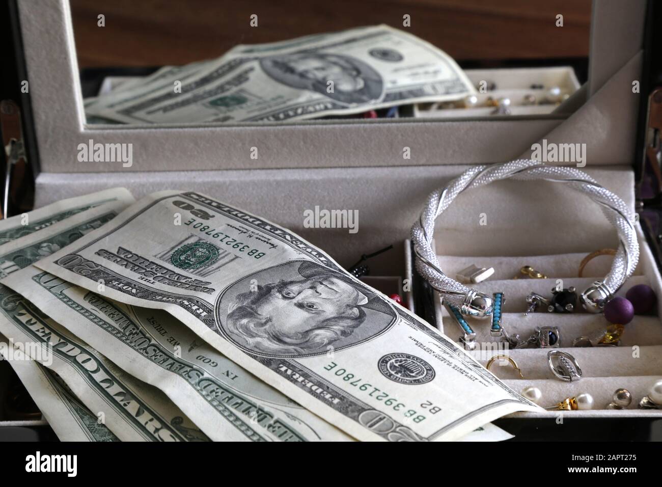 Reflection of box with money and jewelry equally valuable objects Stock Photo