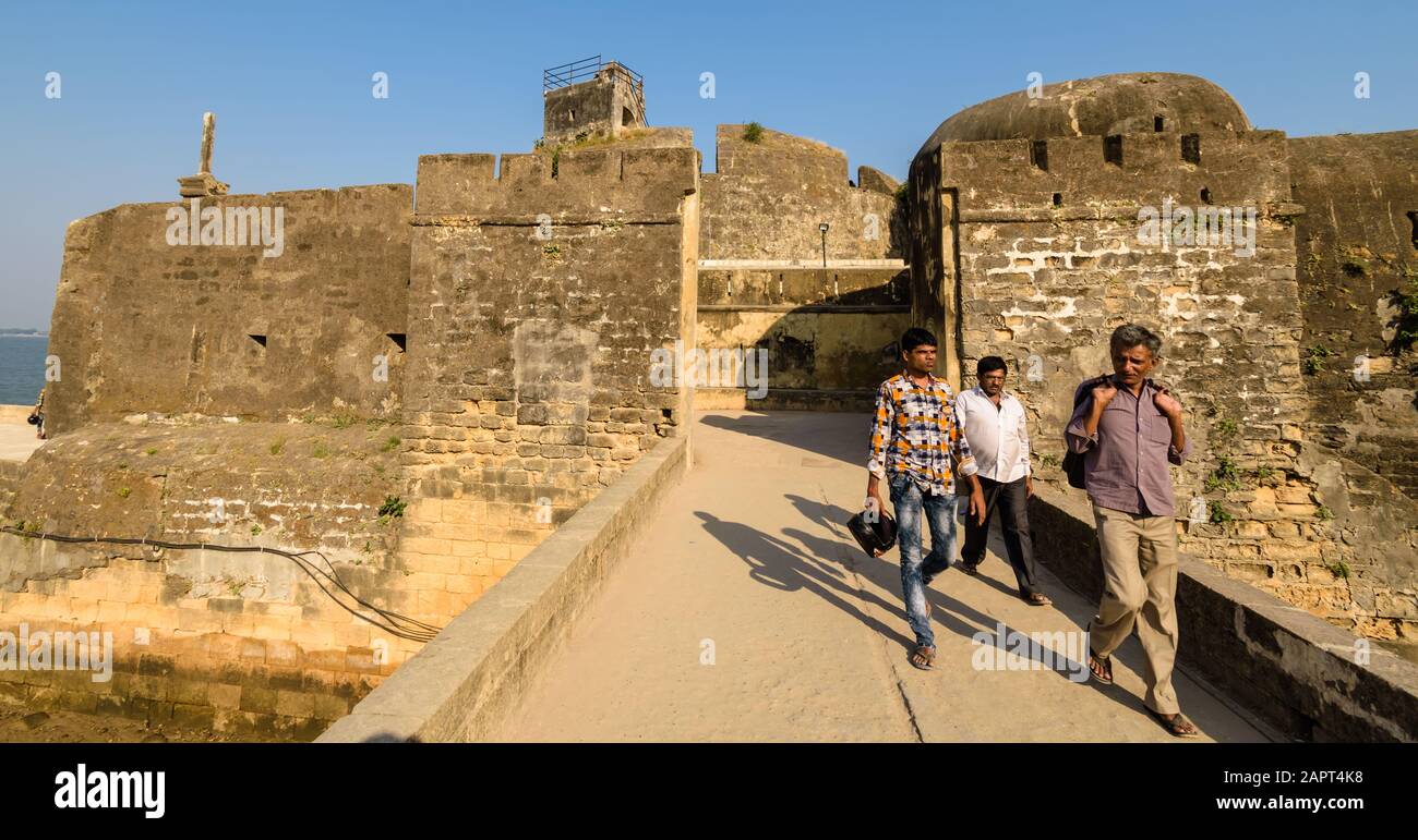 Diu, India - December 2018: A group of tourists walk on a bridge at the ancient Portuguese built Diu Fort. Stock Photo