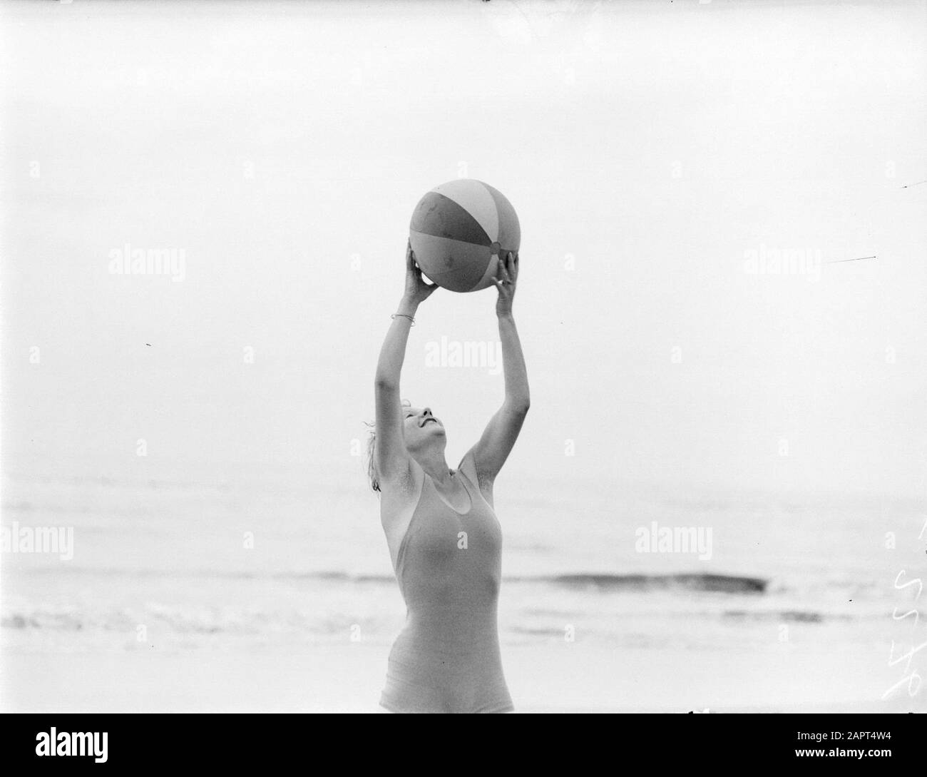 Reportage model  Eva Waldschmidt plays with a ball on the beach Date: 1932 Location: Noord-Holland, Zandvoort Keywords: balls, photo models, beaches Personal name: Waldschmidt, Eva Stock Photo