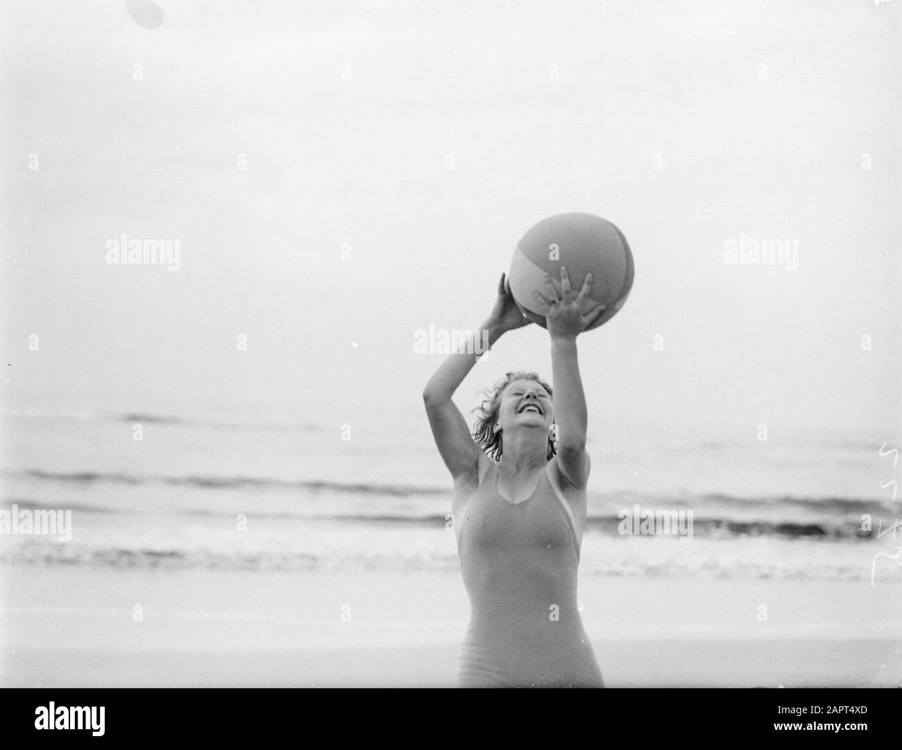 Reportage model  Eva Waldschmidt plays with a ball on the beach Date: 1932 Location: Noord-Holland, Zandvoort Keywords: balls, photo models, beaches Personal name: Waldschmidt, Eva Stock Photo