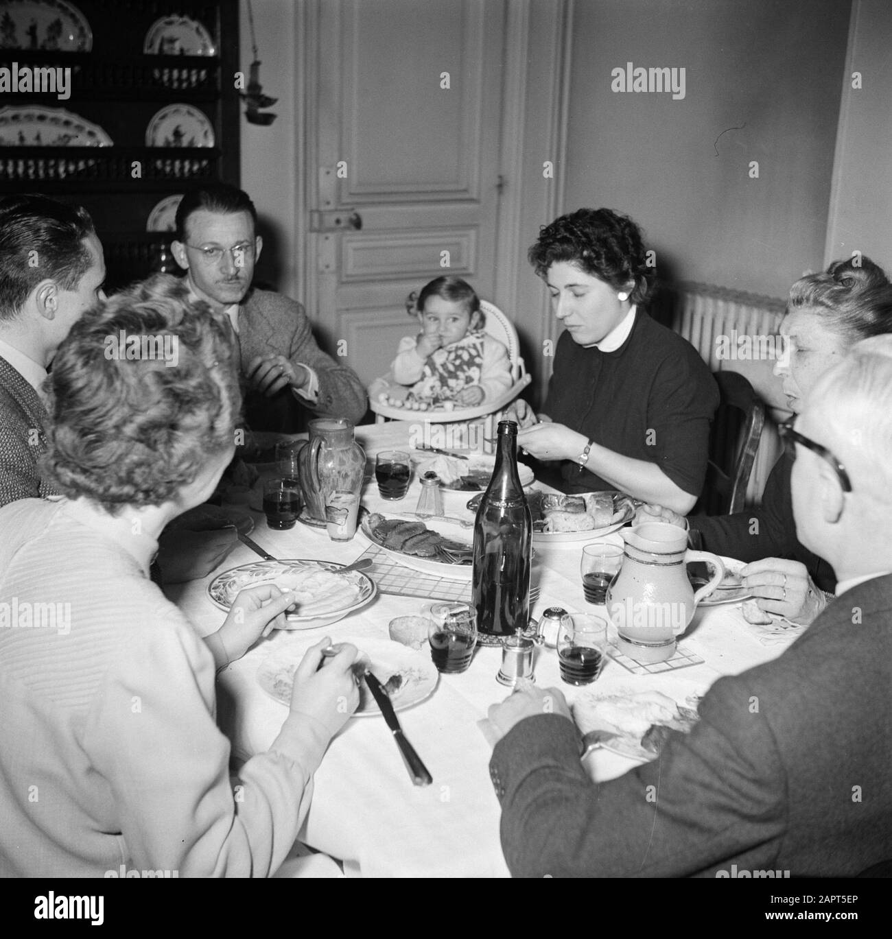 Residents of an apartment building in Paris  Family with guests to the meal Date: 1950 Location: France, Paris Keywords: families, bottles, families, meals, wine Stock Photo