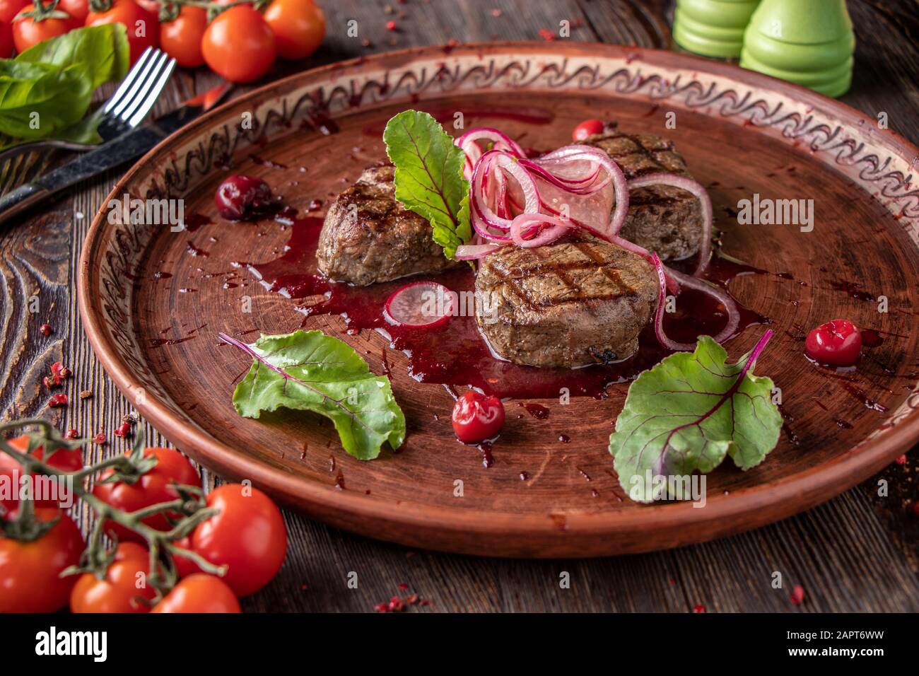 Veal medallions with cherry sauce, served with pickled onions and radishes, a gourmet dish, Horizontal orientation Stock Photo