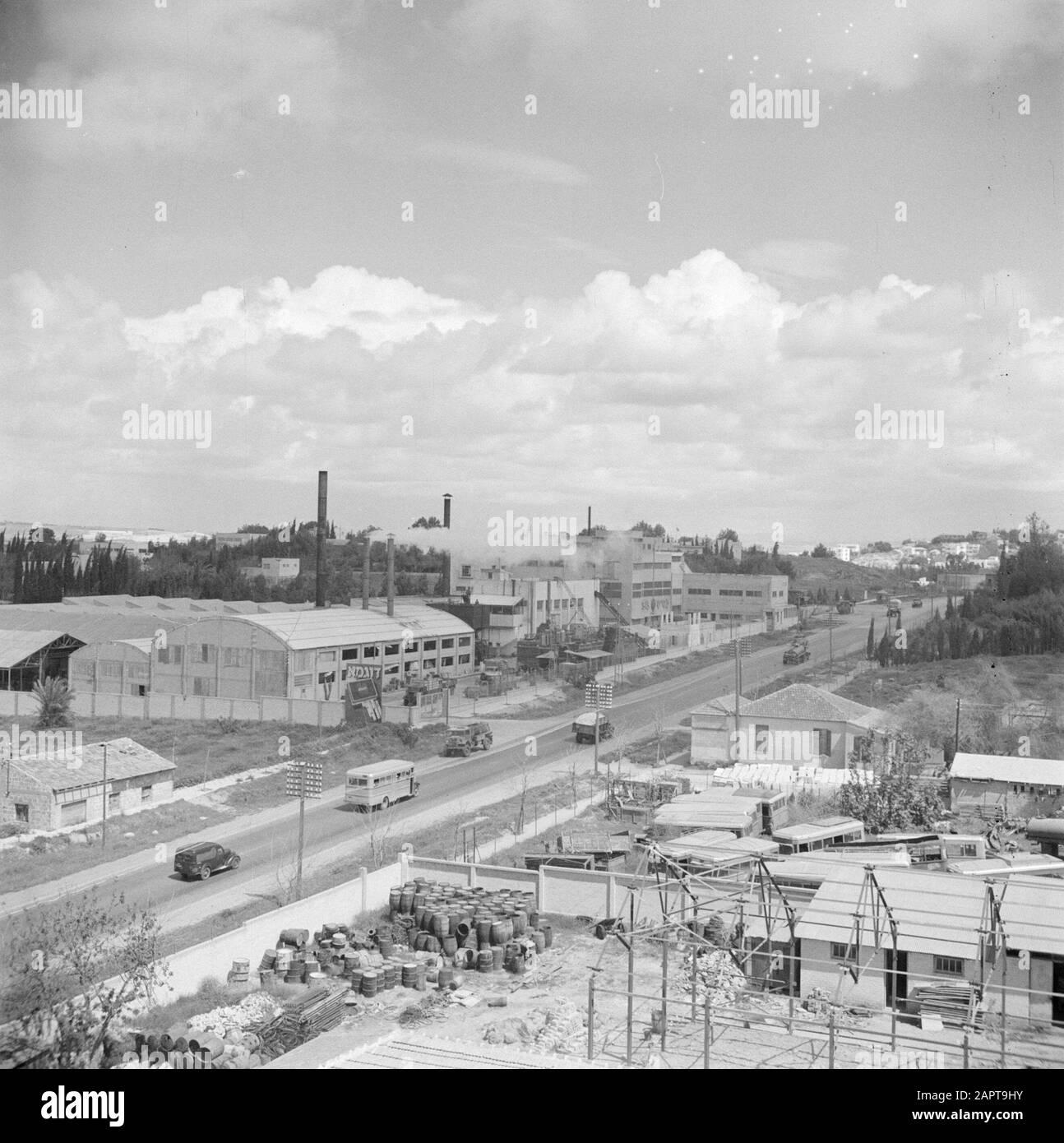 Israel 1948-1949  Buildings of the citrus juice factory Assis on the road from Tel Aviv to Haifa. On the road a.o. a bus and trucks with lower right new construction of production spaces Date: 1948 Location: Haifa, Israel, Tel Aviv Keywords: buses, industrial parks, citrus fruits, factories, fruit growing, industry, new construction, traffic, trucks, fruit juices Stock Photo