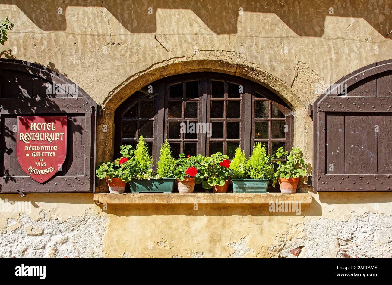 arched window, arched wood shutters, old building, stucco, potted