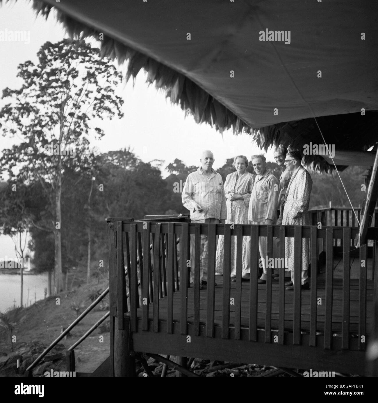 Dutch Antilles and Suriname at the time of the royal visit of Queen Juliana and Prince Bernhard in 1955  Company on the terrace of the guest house in Brokopondo. From left to right the couple De Greve, Mr. De Nit, Lou Hulsebos and Mr. Van Zuylen Date: October 1955 Location: Brokopondo, Suriname Keywords: landscapes, dwellings Personal name: Greve, I.R.J. de, Greve, Jo de, Hulsebos, Lou, Not,  de, Zuylen,  of Stock Photo