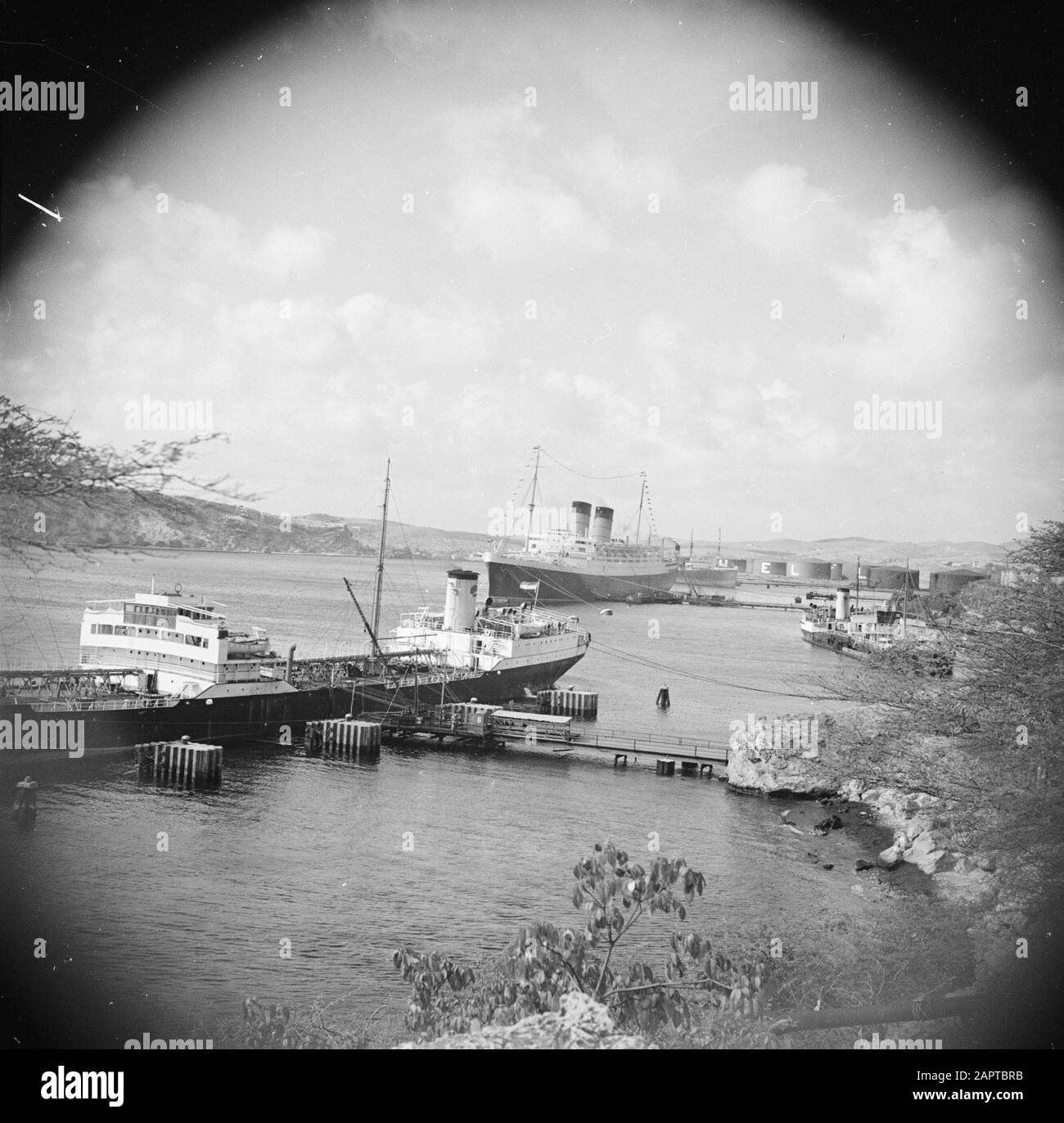 Travel to Suriname and the Netherlands Antilles  View of the jetty at the oil refinery at the Caracas Bay on Curaçao Date: 1947 Location: Curaçao Keywords: refineries, ships Stock Photo