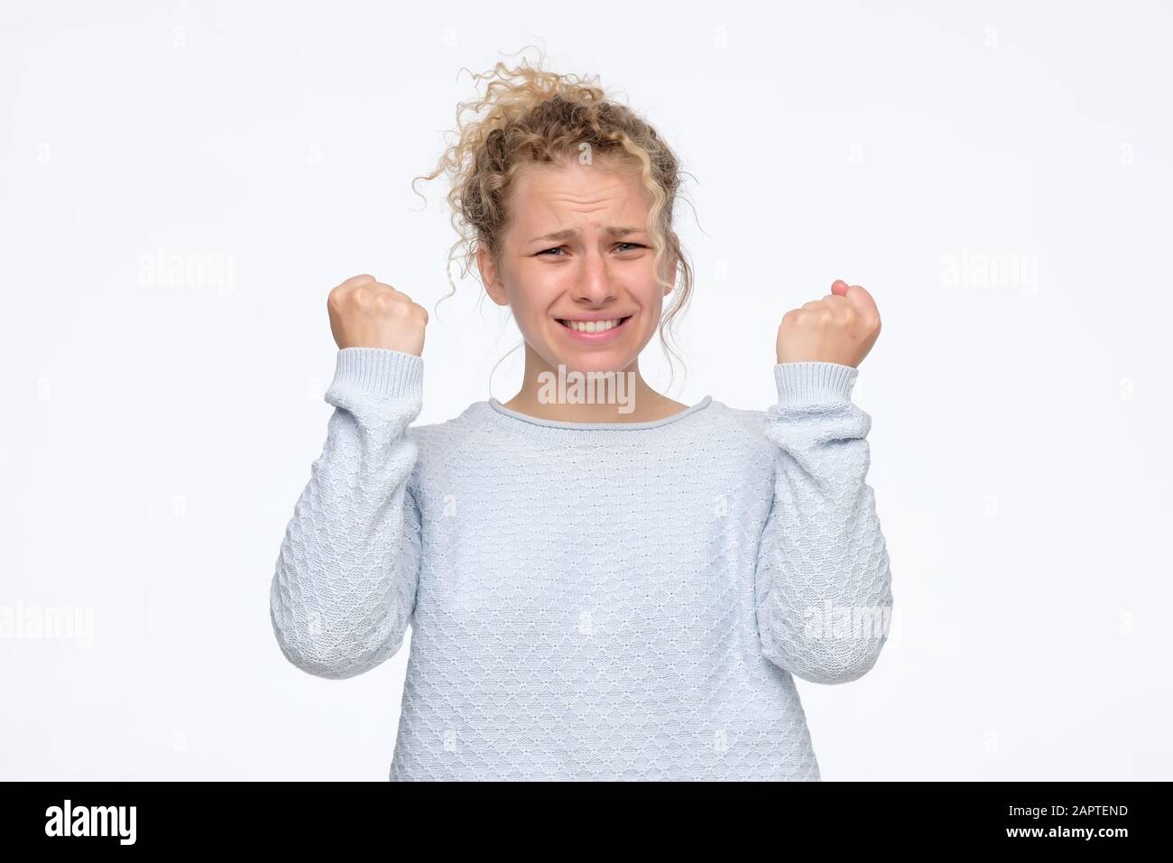 Aggressive angry teenager woman being furious. Studio shot. Negative facial human emotion. Stock Photo