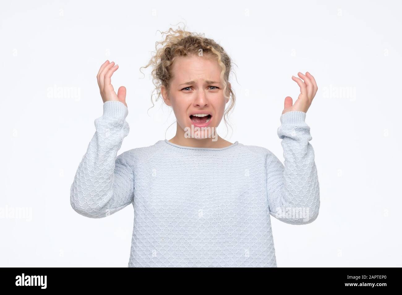 Aggressive angry teenager woman being furious. Studio shot. Negative facial human emotion. Stock Photo