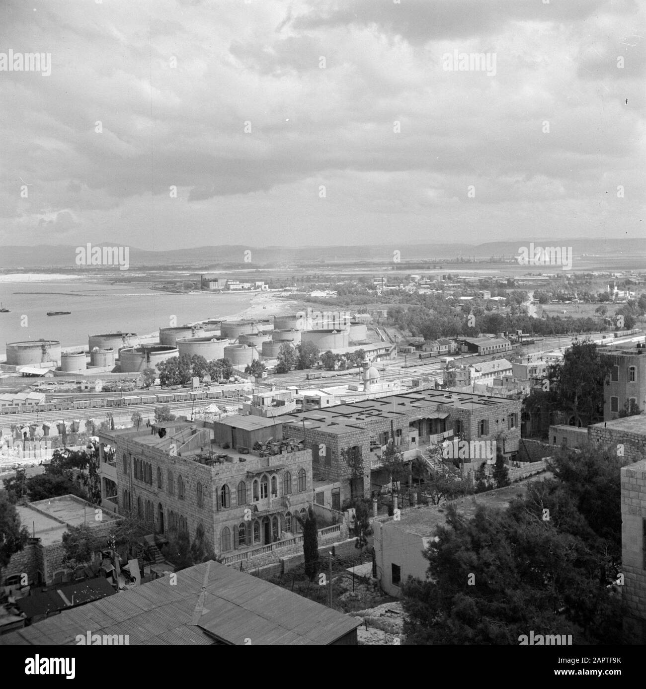 Israel 1948-1949: Haifa  Haifa. City and port with a railway yard and oil installations and with in the foreground dwellings one with roof terrace Date: 1948 Location: Haifa, Israel Keywords: roofs, harbours, storage tanks, panoramas, railways, terraces, homes Stock Photo