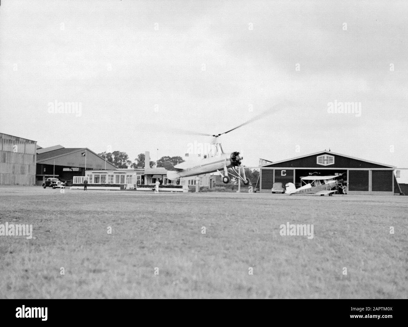 National Aviation School Holland  The takeoff of the Cierva autogiro PH-HHH (Donna Dulcinea) from the Dutch Aviation School at the Rotterdam airport Waalhaven. Right a Koolhoven biplane the PH-FKE Annotation: The Dutch Aviation School was located in Rotterdam Waalhaven and Amsterdam Schiphol Date: 1935 Location: Rotterdam, Waalhaven Keywords: special aircraft, pilots, flight training Personname: Cierva, Juan de, Koolhoven Frits Stock Photo