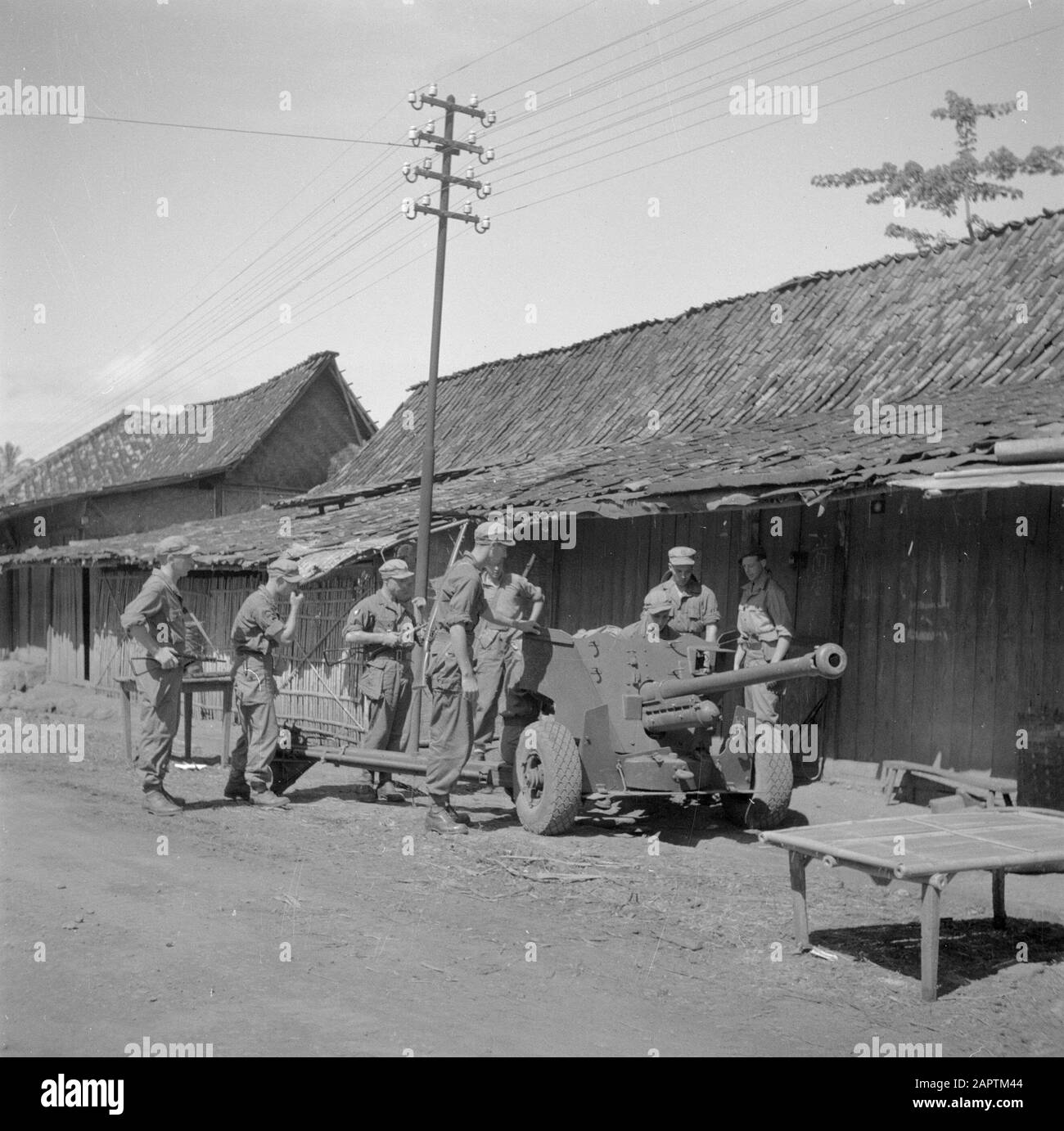 War volunteers in Malacca and Indonesia  Placing light artillery in a kampong Date: March 1946 Location: Indonesia, Indonesia, Java, Dutch East Indies Keywords: artillery, villages, military Stock Photo