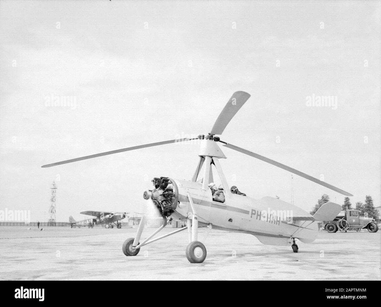 National Aviation School Holland  Starting the Cierva autogiro PH-HHH (Donna Dulcinea) of the Dutch Aviation School at the Rotterdam airport Waalhaven. Left a parked Fokker XII passenger plane Date: 1935 Location: Rotterdam, Waalhaven Keywords: special aircraft, pupils, teachers, pilots, flight trainings Personal name: Cierva, Juan de, Fokker, Anthony Stock Photo
