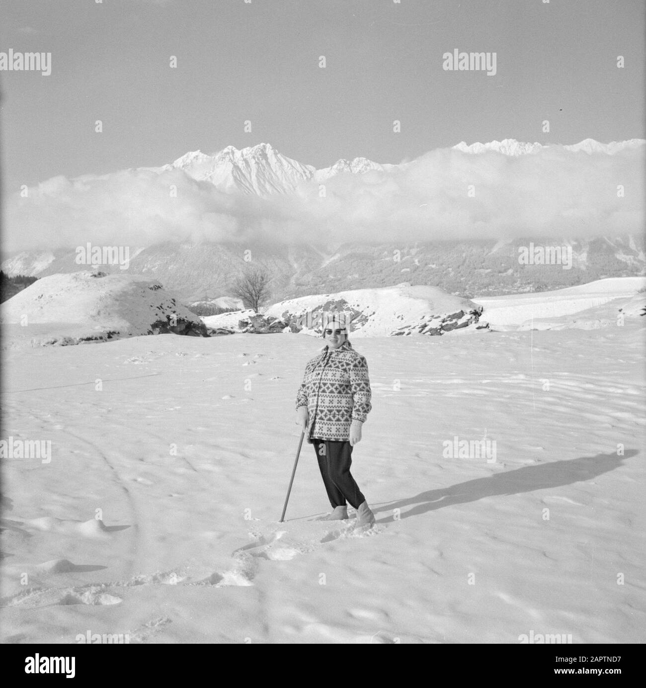 Winter in Tyrol  Hilde Eschen poses in the snow with in the background the Karwendel Mountains Date: January 1960 Location: Austria, Sistrans, Tyrol Keywords: mountains, landscapes, snow, holiday, hiking, winter Personal name: Echen, Hilde Stock Photo