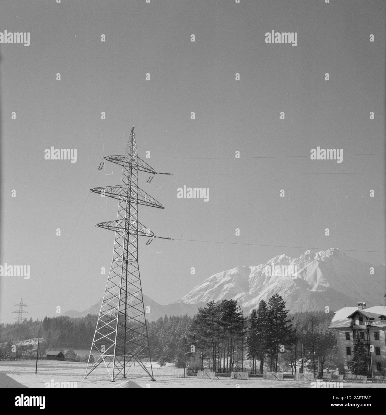 Winter in Tyrol  High voltage mast with the Karwendel Mountains in the background Date: January 1960 Location: Austria, Sistrans, Tyrol Keywords: mountains, electricity, high voltage masts, landscapes, snow, winter Stock Photo