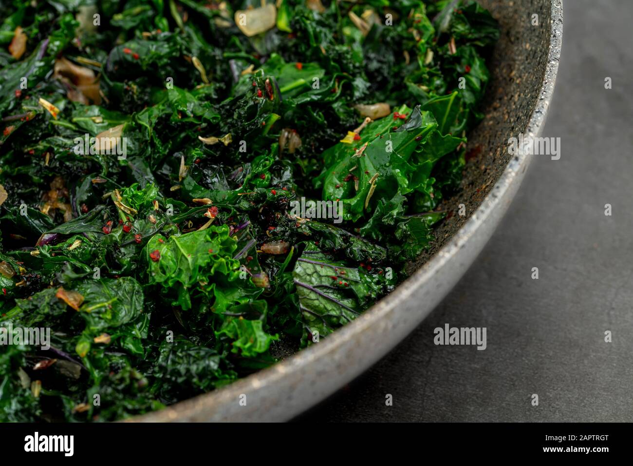 sauteed kale with onion in a pan with olive oil, healthy cooking