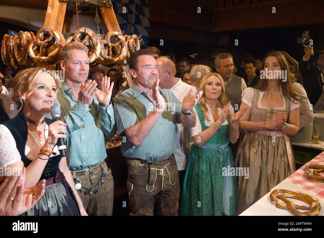 24 January 2020, Austria, Kitzbühel: Stanglwirt hostess Maria Hauser (l-r), Patrick Mario Knapp Schwarzenegger, nephew of Arnold Schwarzenegger, actor Arnold Schwarzenegger, Schwarzenegger's girlfriend Heather Milligan and Schwarzenegger's daughter Christina clap their hands at the Weißwurst Party at the Stanglwirt, one day before the legendary Hahnenkamm Race. The events surrounding the Streif are among the most important celebrity events of the year in Austria. Photo: Felix Hörhager/dpa Stock Photo
