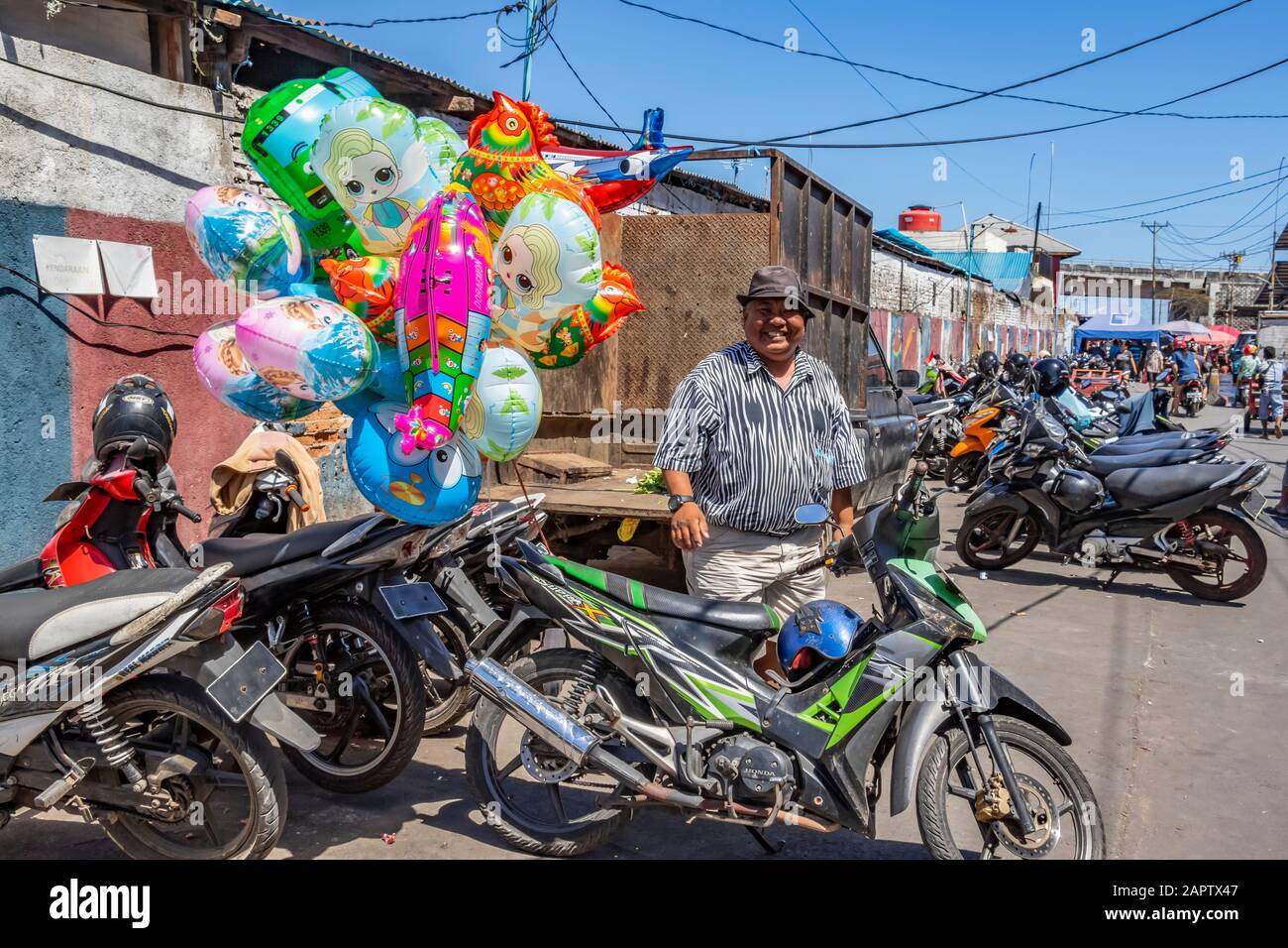 Man standing by a motorcycle with balloons; Manado, North Sulawesi, Indonesia Stock Photo