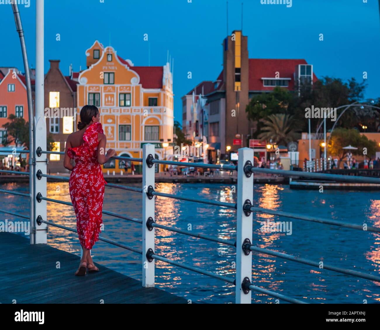 Saint Anna Bay, St Anna Bay, Willemstad, Curaçao - 10/22/2019. Qeen Emma Bridge. Girl/Teen/Women/Model walking along the bridge enjoying the city view Stock Photo