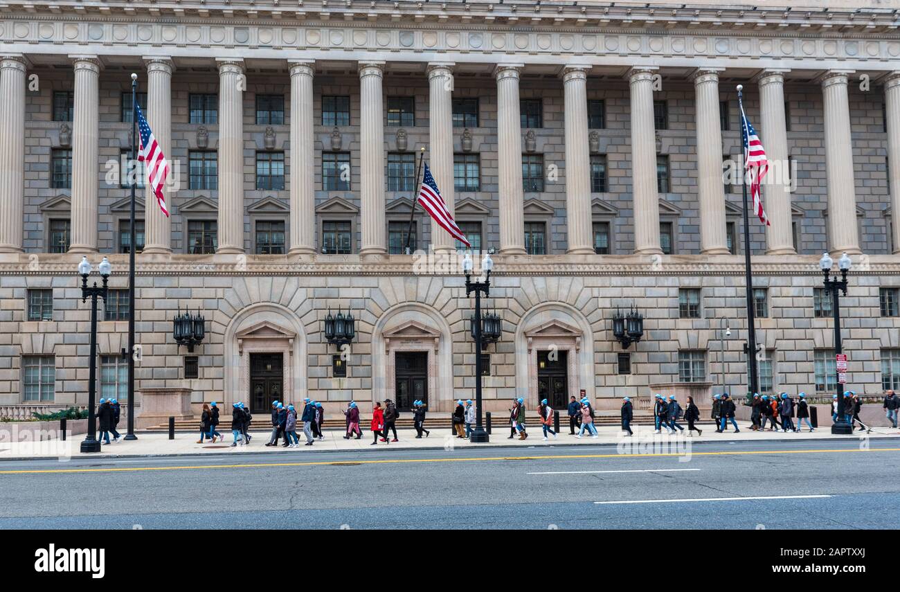 Washington DC, USA — March 24, 2020. People walk past the Department of Commerce Building as they head for the annual March for Life Rally in Washingt Stock Photo