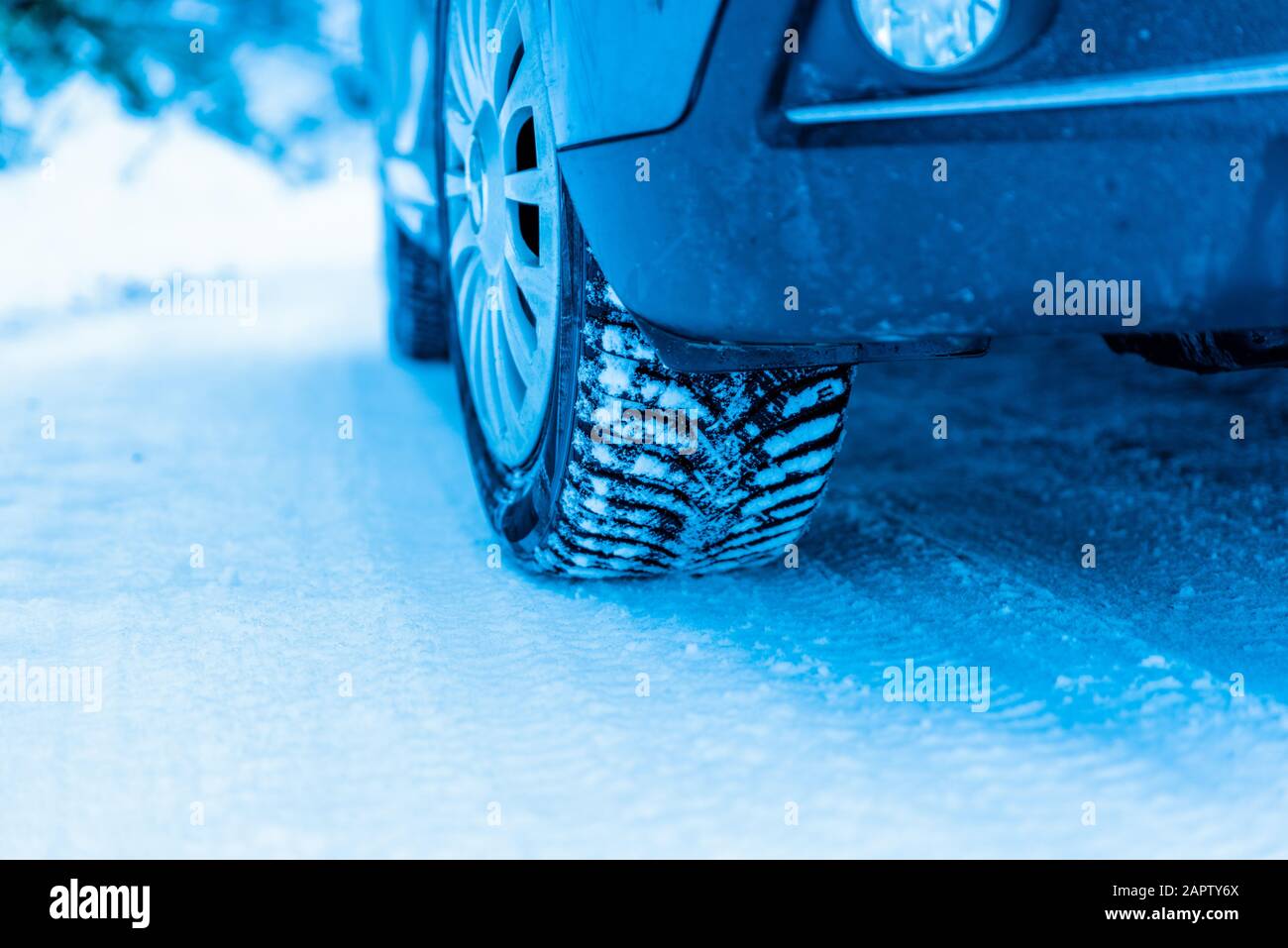 Winter tire on a vehicle on a snowy surface. Close-up Stock Photo