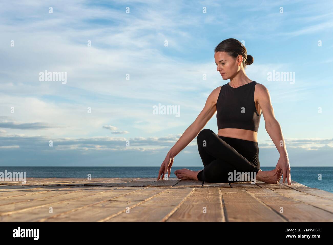 woman practicing morning meditation in nature by the sea, healthy lifestyle concept. Stock Photo