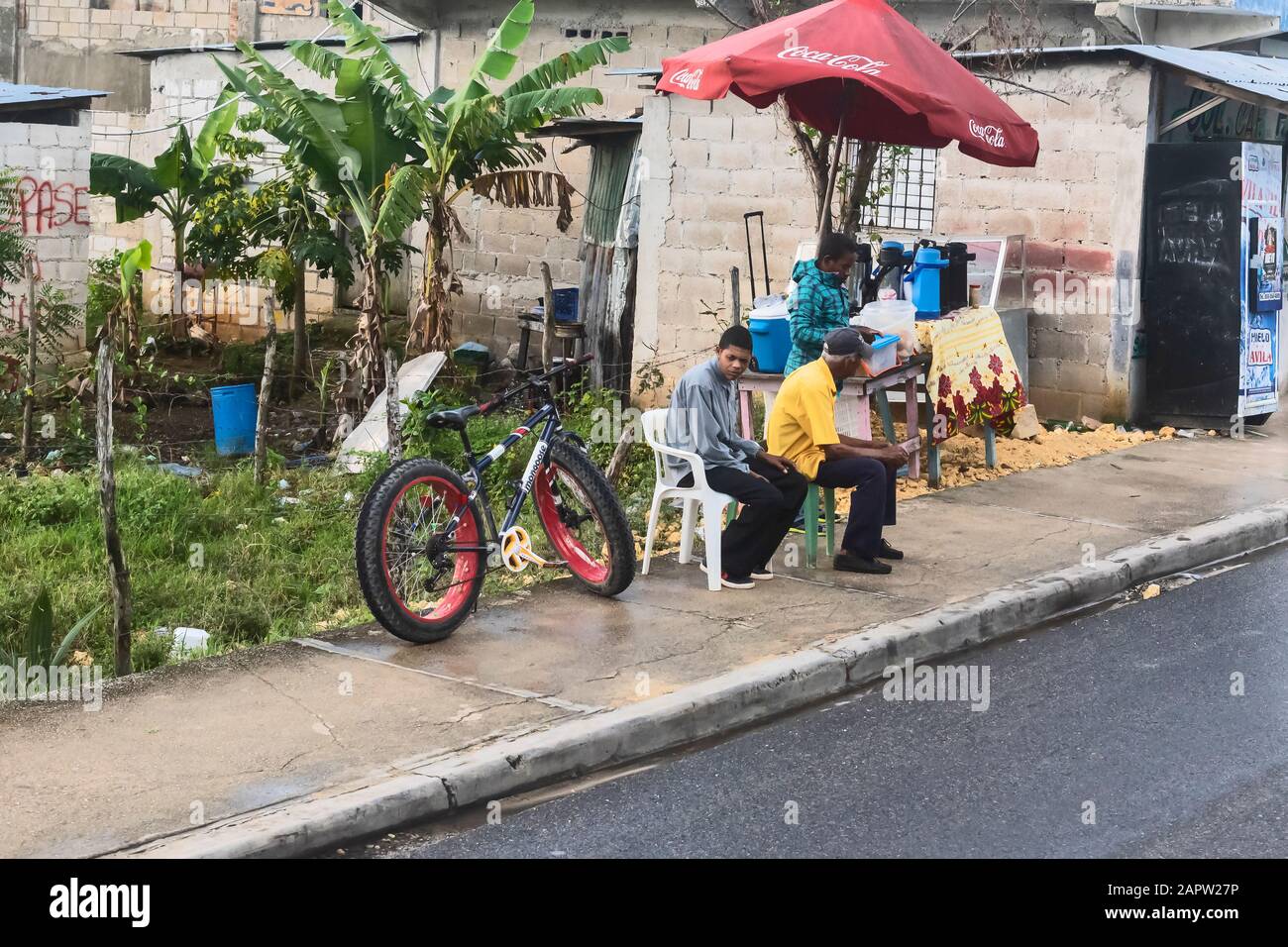 Three people on the street waiting for transport , Dominican Republic Stock Photo