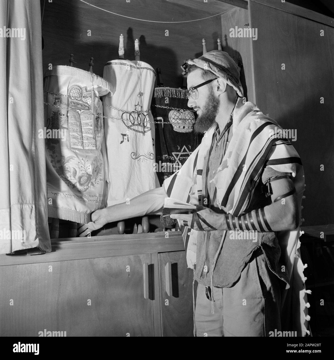 Jewish man with a hat on, a prayer cloak on and fitted with prayer