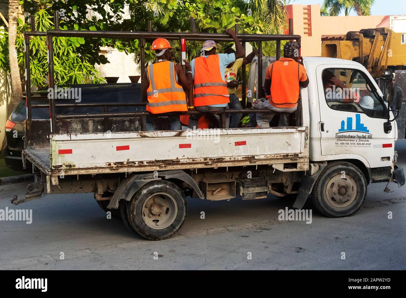 Workers sit in the back of a truck, returning from work, Dominican