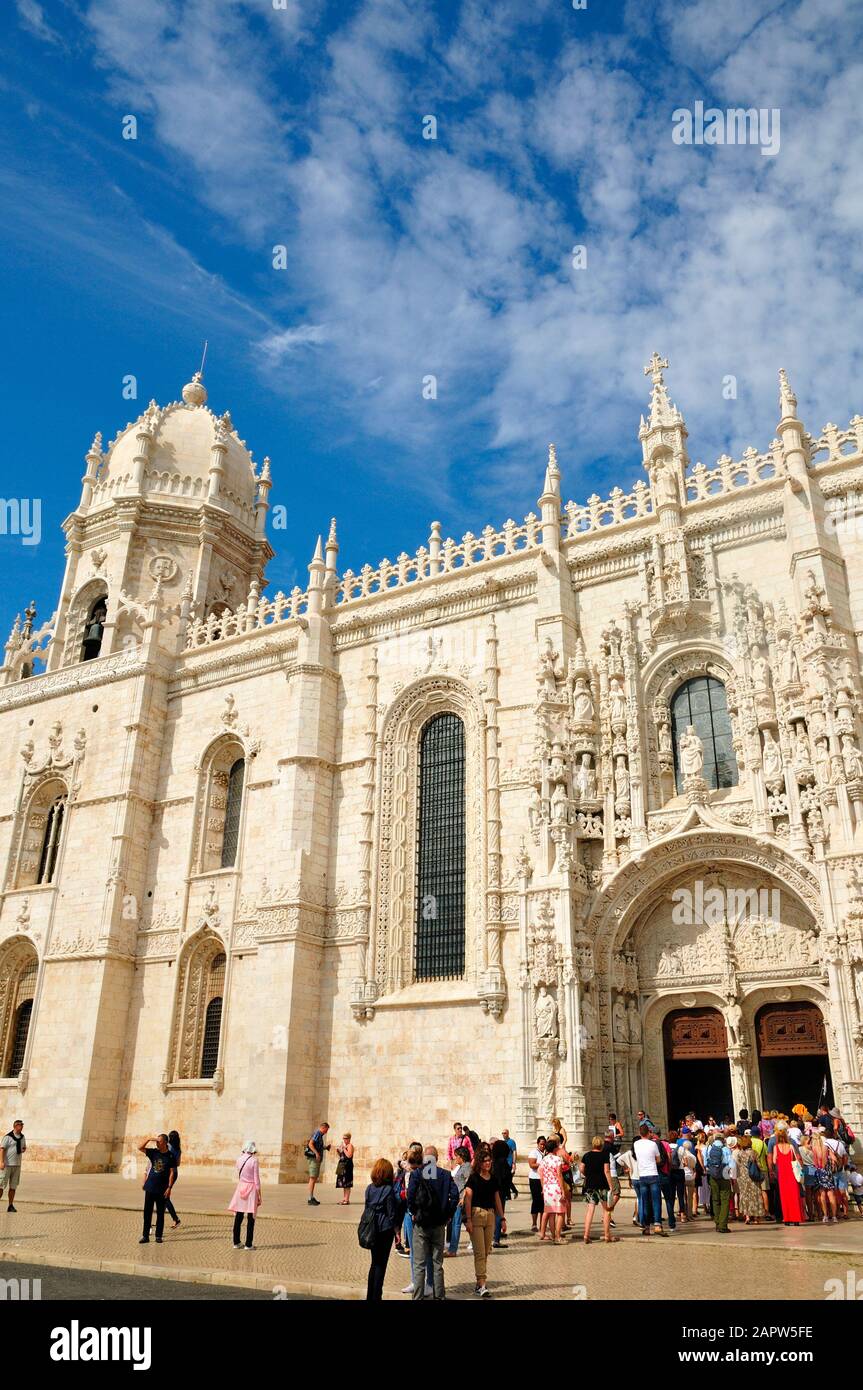 An exterior view of the Jeronimos Monastery, Belem, Portugal, with a crowd of tourists queueing at the entrance of the south portal Stock Photo