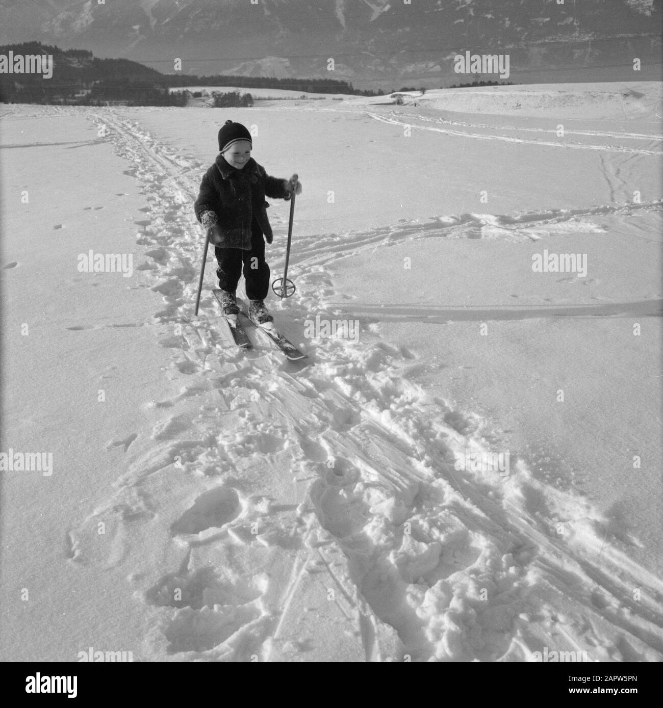 Winter in Tyrol  Child with skis in the snow with the Karwendel Mountains in the background Date: January 1960 Location: Austria, Sistrans, Tyrol Keywords: mountains, landscapes, cross-country skiing, skiing, snow, winter, winter sports Stock Photo