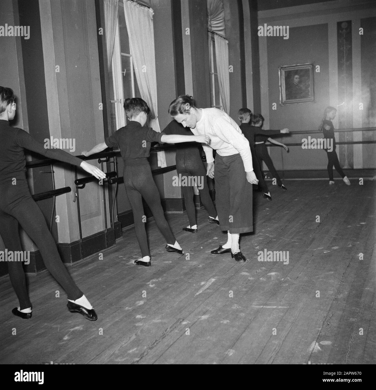 Training of the Royal Danish Ballet  Children are taught at the barre in a rehearsal room Date: March 1954 Location: Denmark, Copenhagen Keywords: ballet, dancers, dance training, artistic education, teachers, education Institution name: Royal Ballet School Stock Photo