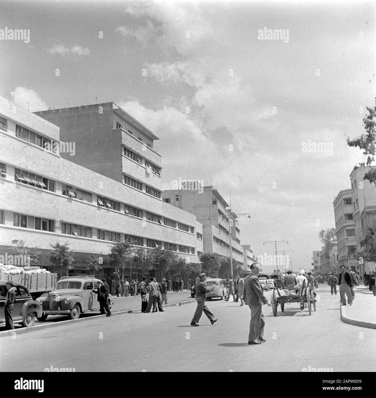 Israel 1948-1949: Haifa  Kingsway, the main street of the port area Date: 1948 Location: Haifa, Israel Keywords: cars, apartment buildings, carts, street images, pedestrians Stock Photo