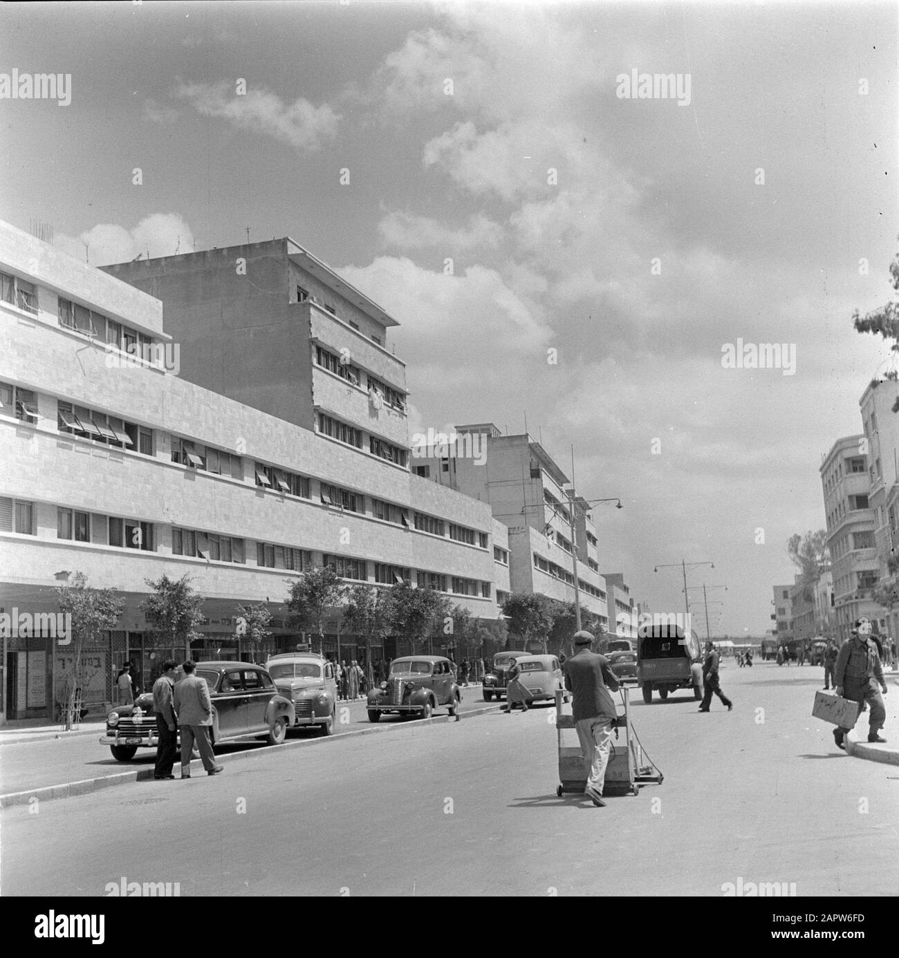 Israel 1948-1949: Haifa  Kingsway, the main street of the port area Date: 1948 Location: Haifa, Israel Keywords: cars, apartment blocks, cleaning services, street images, pedestrians Stock Photo