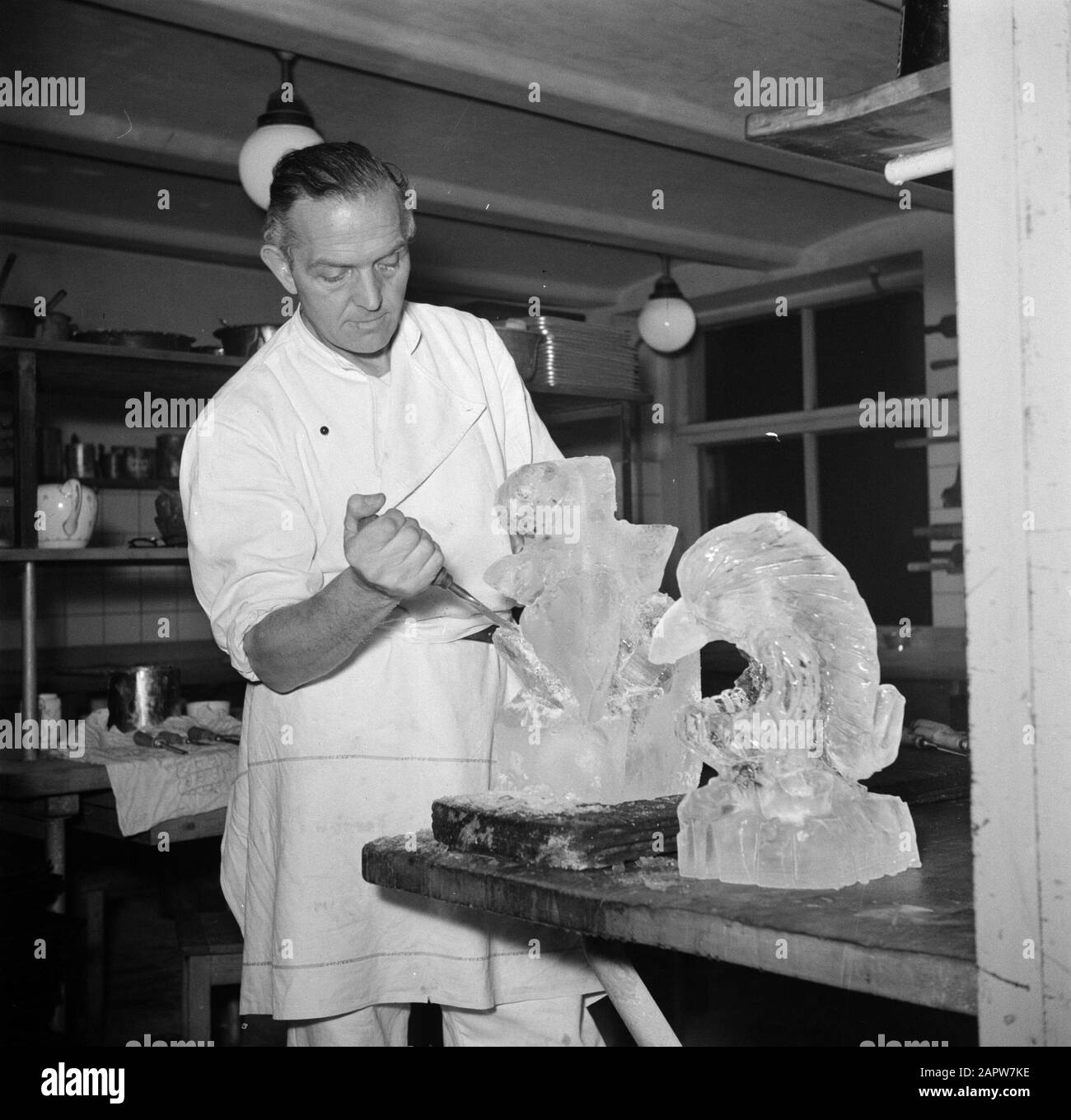 Restaurant Wivex located in the facade building of Tivoli park  Kok makes ice sculptures in the kitchen of restaurant Wivex Date: March 1954 Location: Denmark, Copenhagen Keywords: sculpture, sculptures, headgear, catering staff, ice cream, kitchens, clothing, cooks, restaurants, crockery Institution name: Wivex Stock Photo