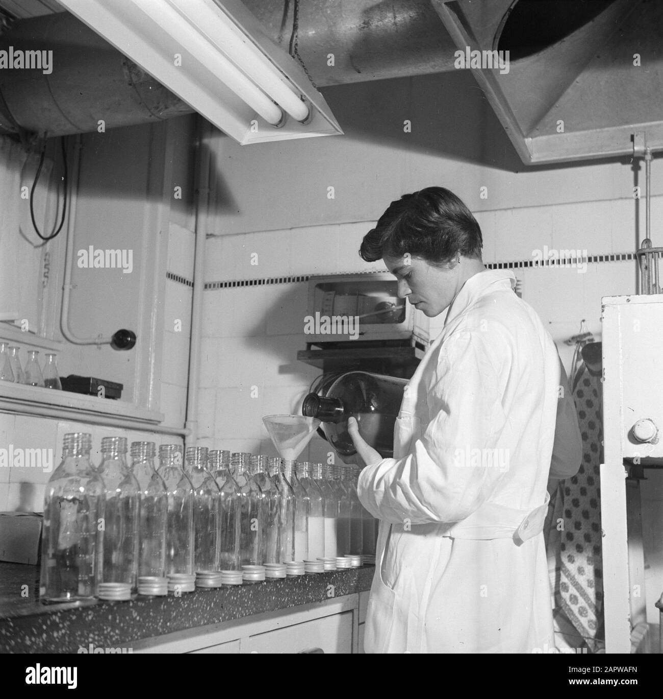 Mother's milk plant of the Dutch Red Cross  Laborante fills bottles with milk Date: May 1954 Location: Amsterdam, Noord-Holland Keywords: biochemistry, breastfeeding, bottles, healthcare, laboratory technicians, medical equipment Institution name: Red Cross Stock Photo
