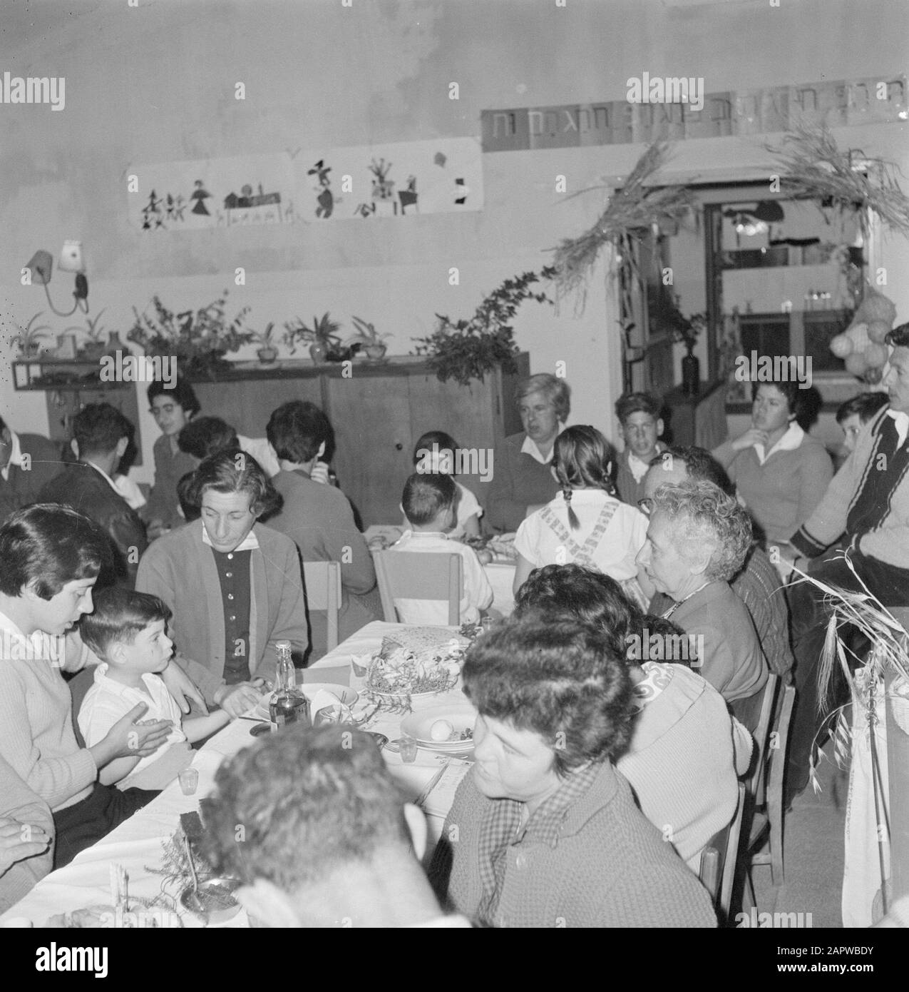 Israel 1964-1965: Gal'ed, since evening  Members of the kibbutz Gal'ed during the Seidermeal Annotation: Gal'ed (also called Even Yitzhak) is a kibbutz in northern Israel, located in the plain of Manasse. In 2006 it had a population of 405. Seder Evening (also called Seideravond) is an evening at the beginning of the Passover festival, where Jews from the Haggada read (booklet about the story of Jewish slavery in Egypt and the exodus from Egypt), drink 4 glasses of wine (or grape juice) and a festive sedermeal. Seder literally means order or order, because the customs are performed according t Stock Photo