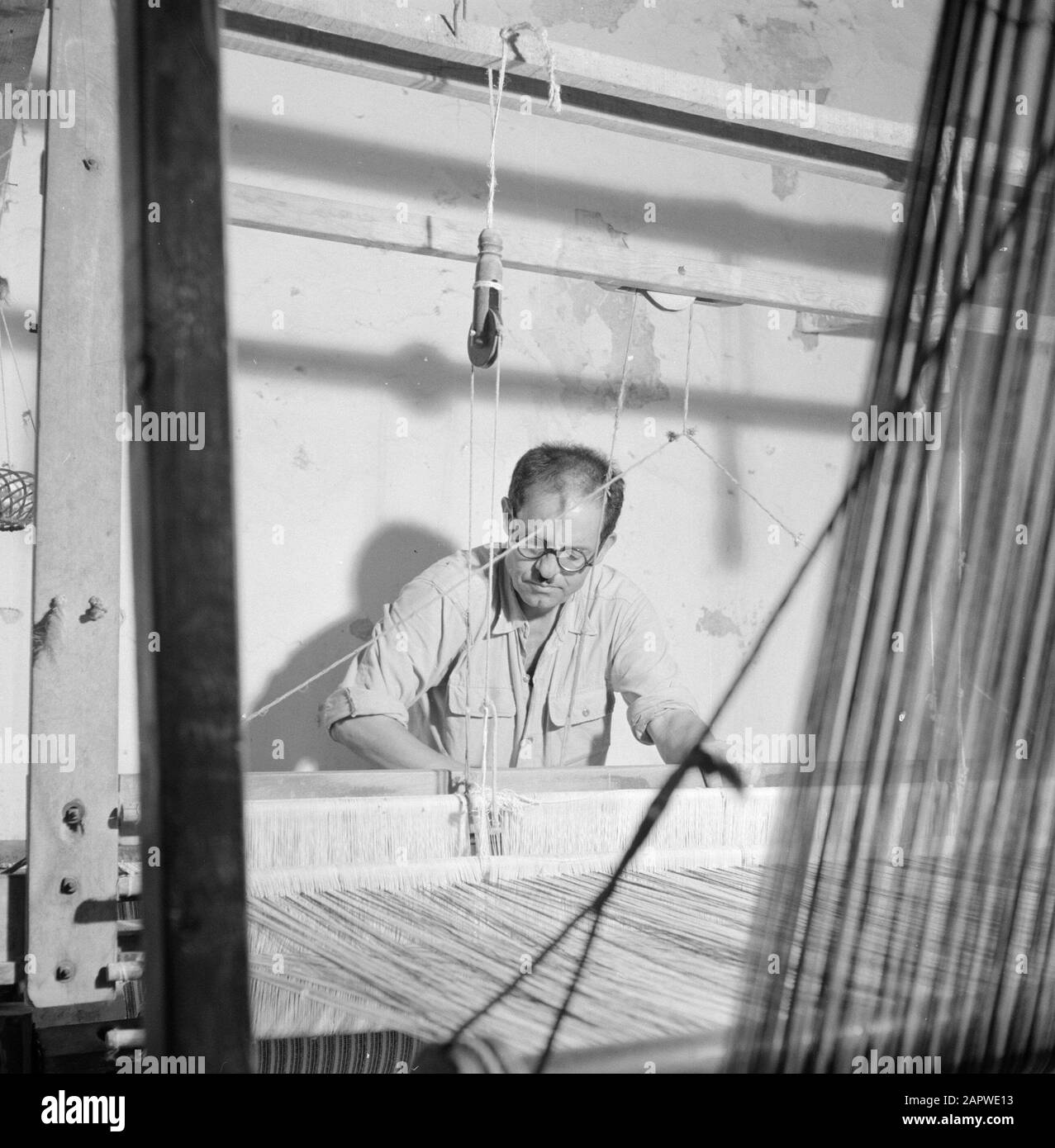 Man on a loom Date: January 1, 1964 Location: Israel Keywords: collaborators, weaving Stock Photo